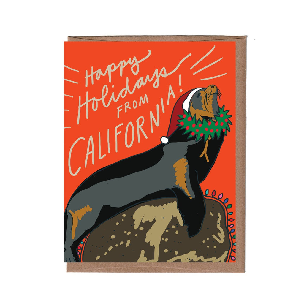 Card with a California sea lion wearing a Santa hat and wreath on an orange background with 'Happy Holidays from California!' text.