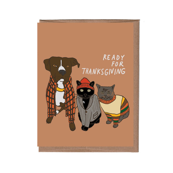 Card with illustrations of a dog and two cats wearing Thanksgiving-themed clothing on a brown background.